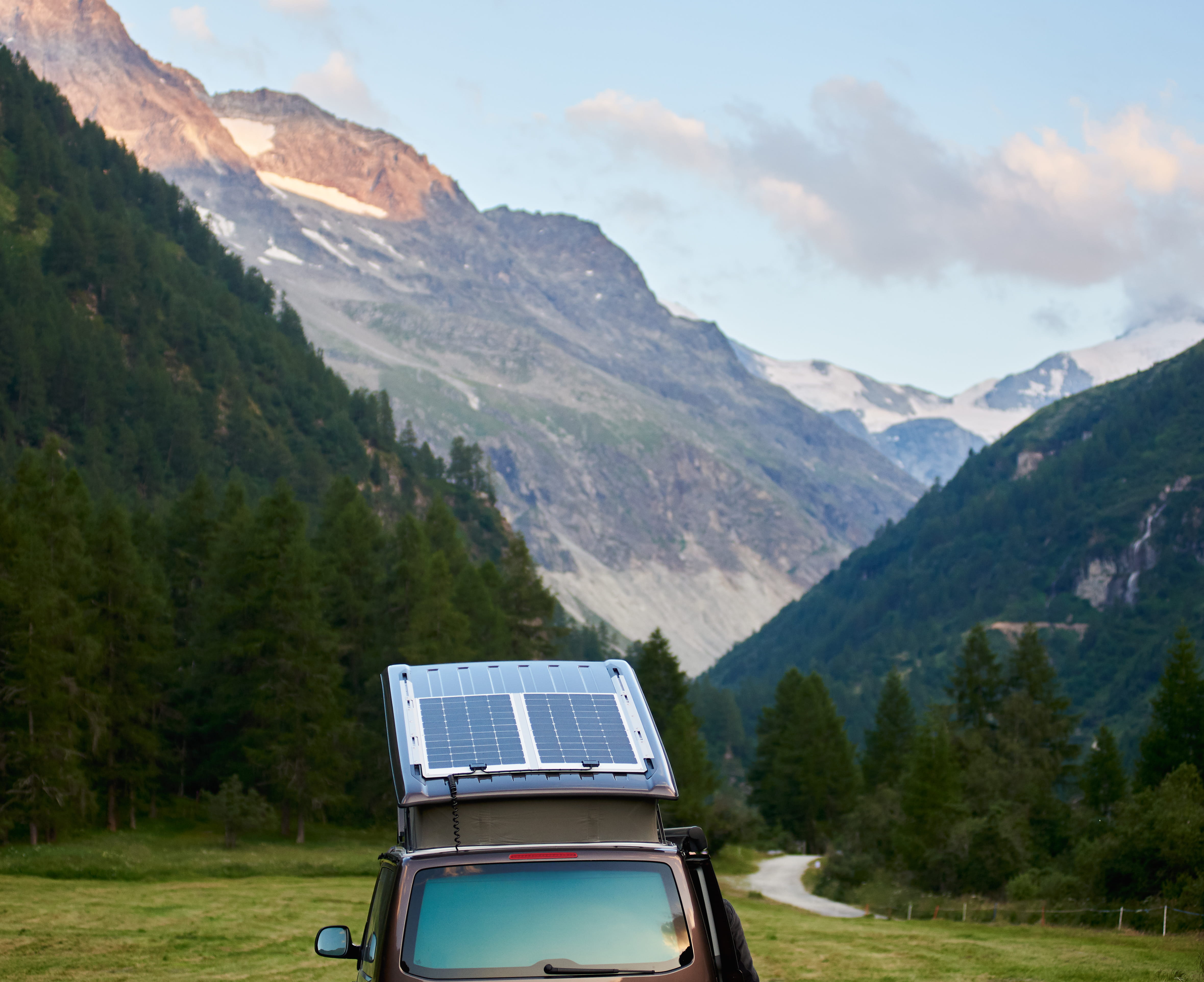 Campervan with roof solar panels in the mountains